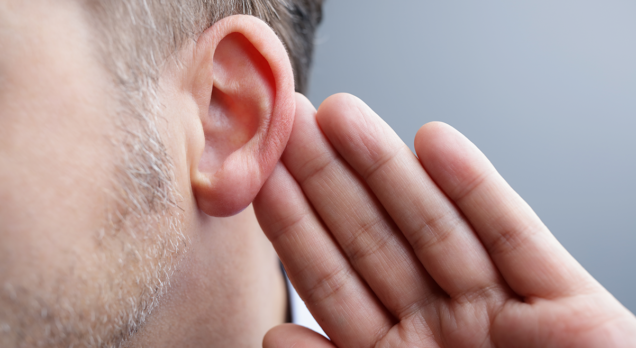 Man listening with hand by ear